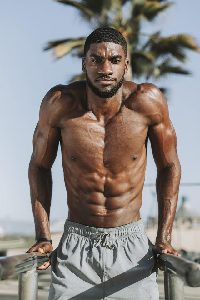 Topless muscular black man doing dip exercises 