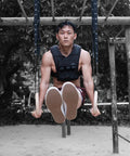 man wearing grav weighted vest doing l-sit on grav gymnastic rings